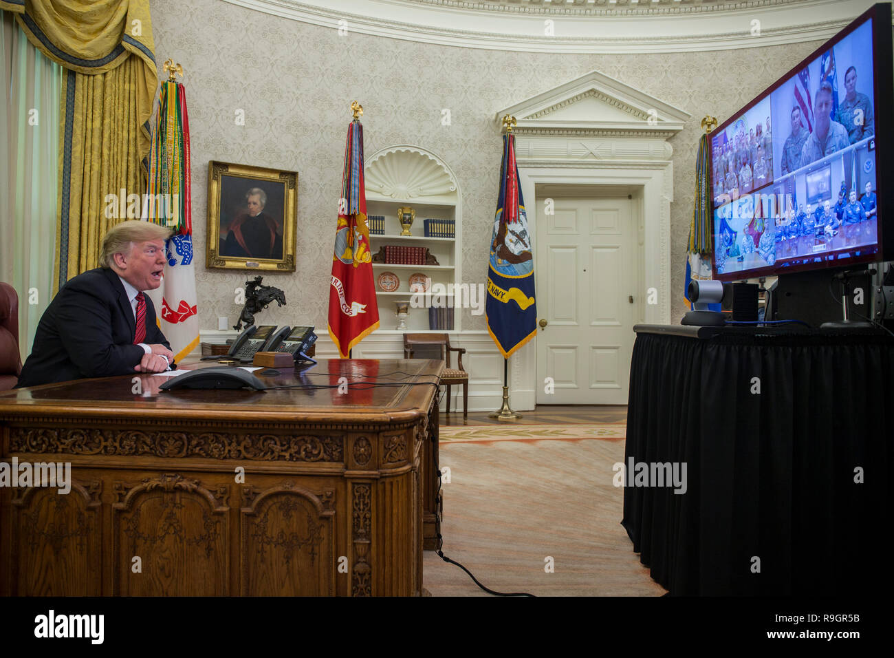 Washington, DC, USA. Dec 25, 2018. Le Président des Etats-Unis, Donald J. Trump fait un appel vidéo pour les membres en service de l'Armée, Marine Corps, la marine, la Force aérienne et de la garde côtière en poste dans le monde entier, dans le bureau ovale à la Maison Blanche à Washington, DC, États-Unis, le 25 décembre 2018. Credit : Zach Gibson/Piscine via CNP | Conditions de crédit dans le monde entier : dpa/Alamy Live News Banque D'Images