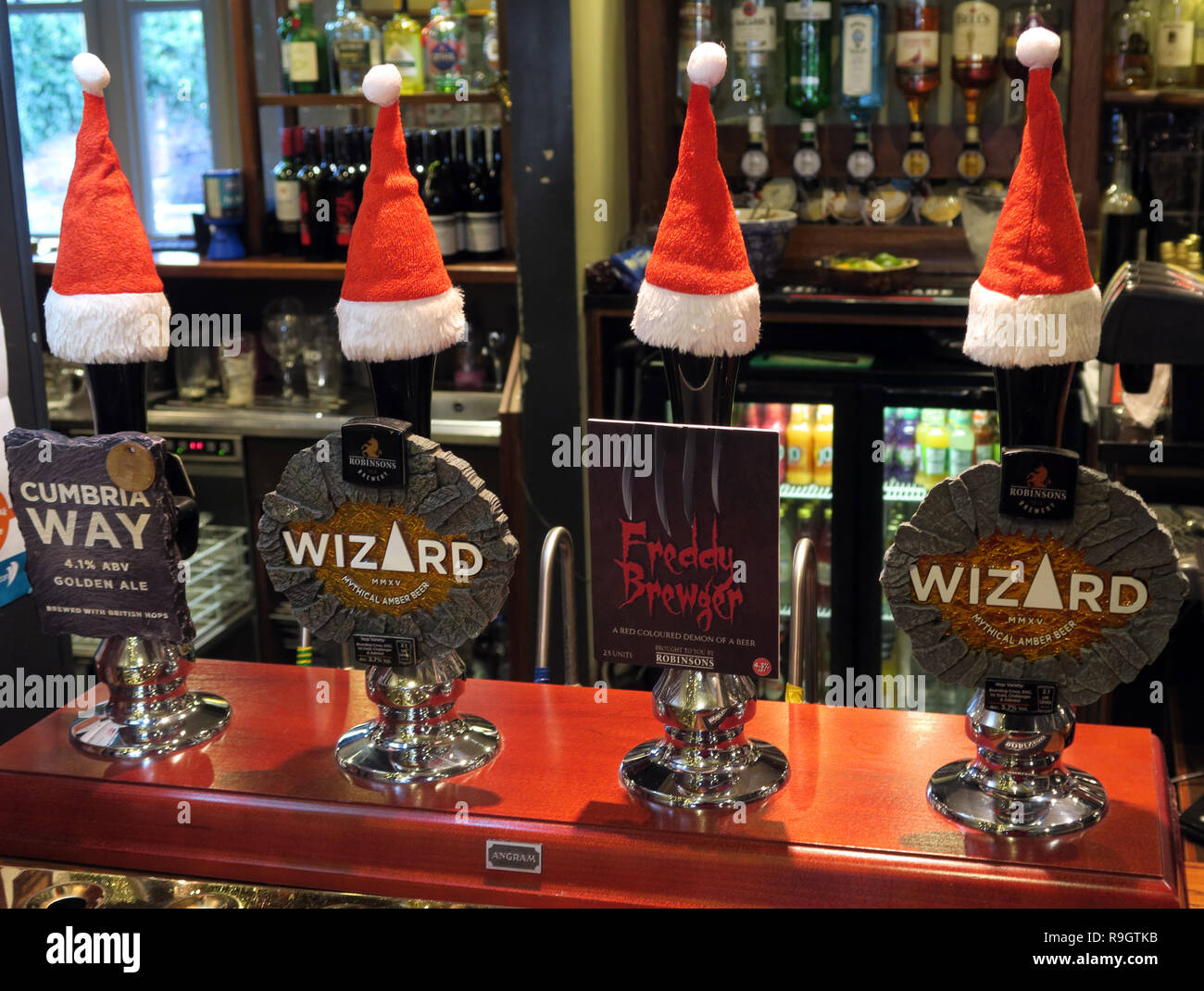 Brasserie Robinsons Stockport, bar Real Ale des pompes, avec un chapeau de Noël, façon de Cumbrie, assistant, Freddy Brugar, sur un bar, Parr, Grappenhall Warrington, armes Banque D'Images