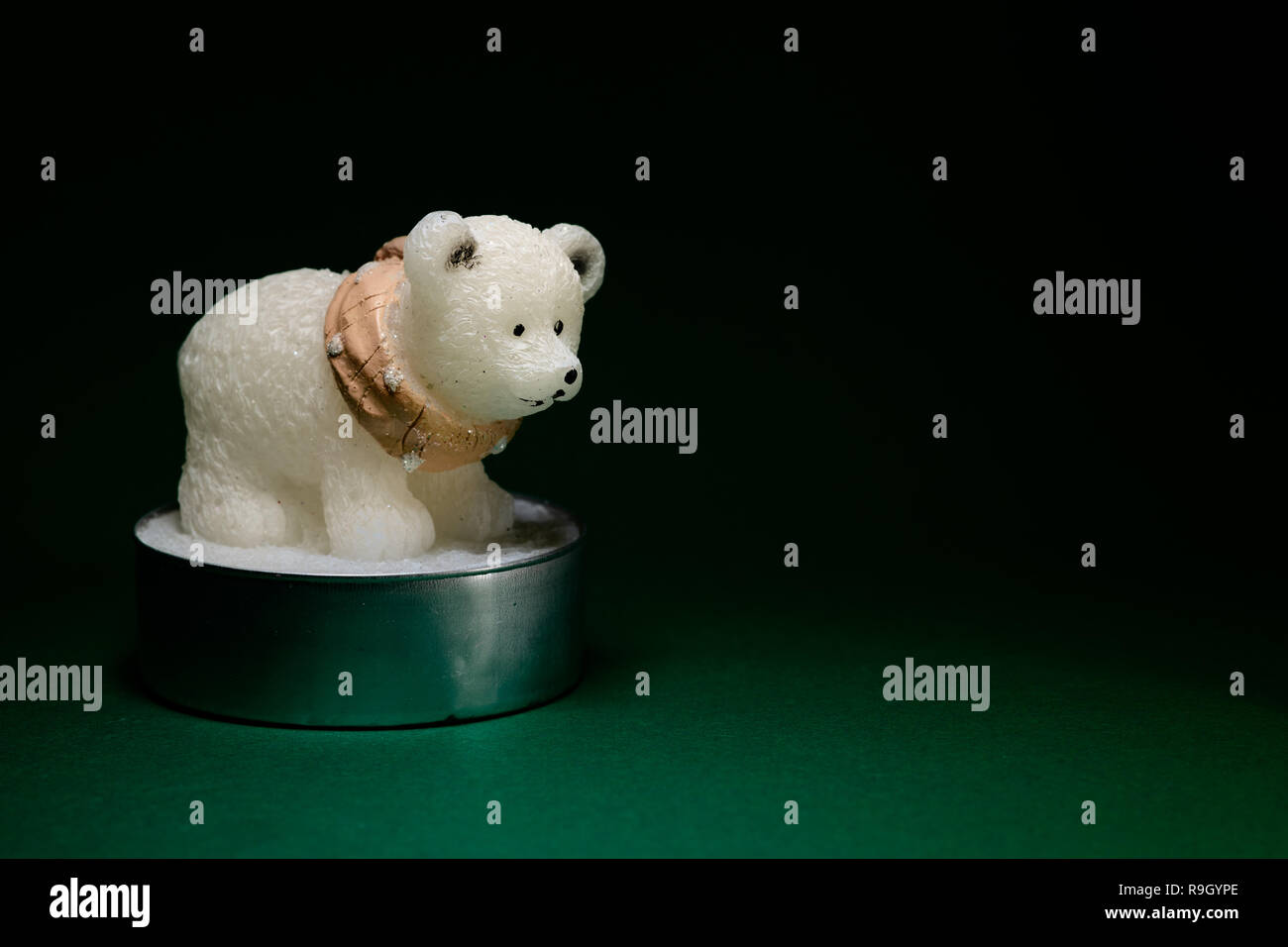 Figurine ours polaire bougie sur fond vert, concept de décoration intérieure Banque D'Images