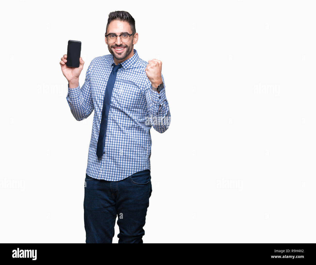 Jeune homme d'affaires montrant l'écran du smartphone sur fond isolé crier fier et célébrer la victoire et le succès très excités, ils applaudissent emoti Banque D'Images