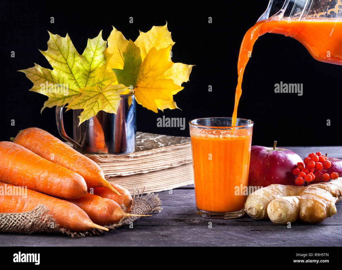 La carotte fraîche, pomme, jus de gingembre sur fond de bois en automne Banque D'Images