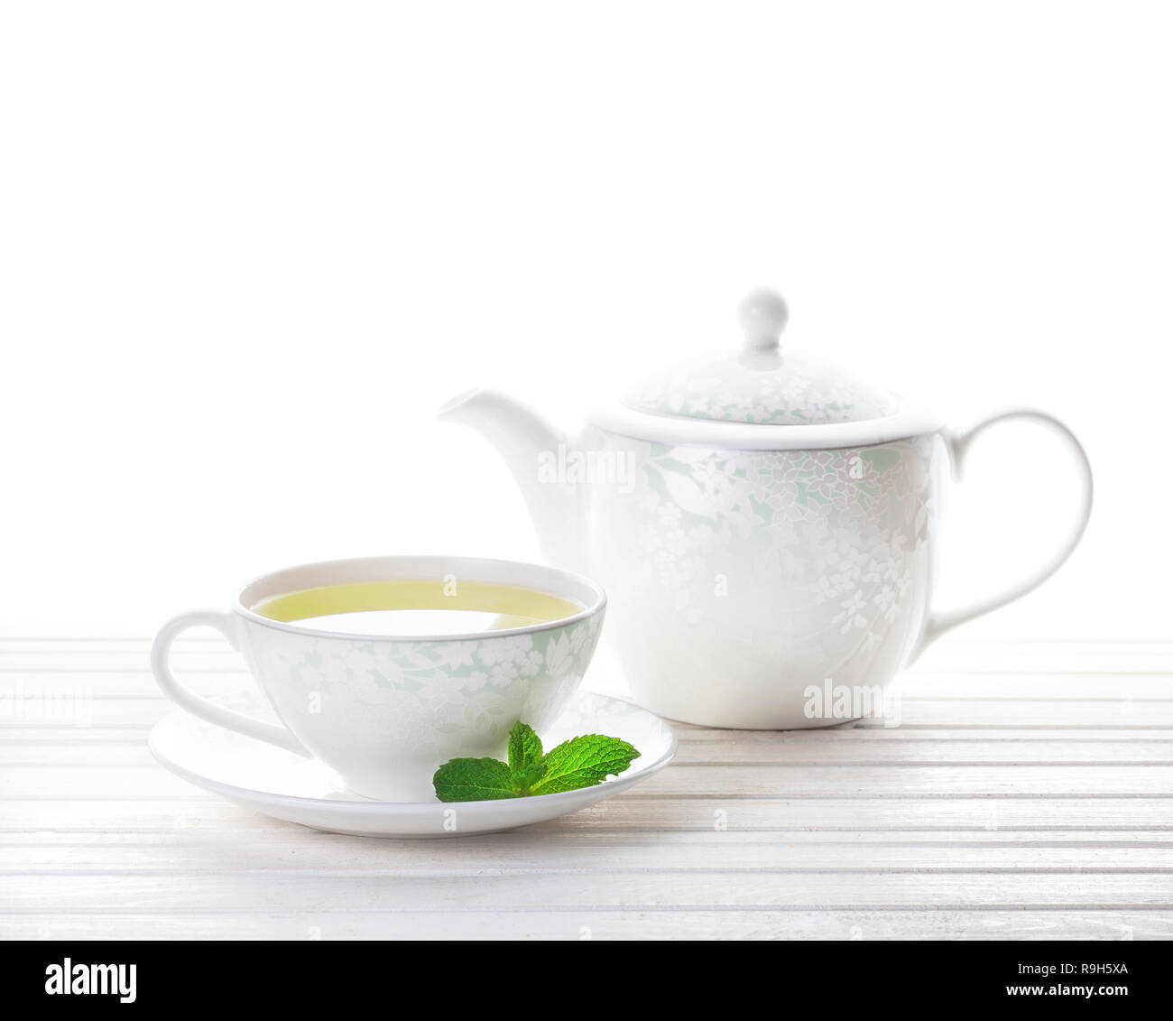 Thé à la menthe dans la théière tasse près à fond blanc Banque D'Images