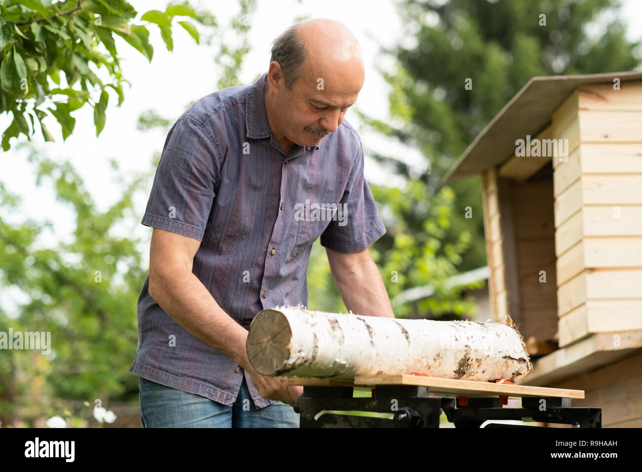 Vieil homme vu log dans le jardin Banque D'Images