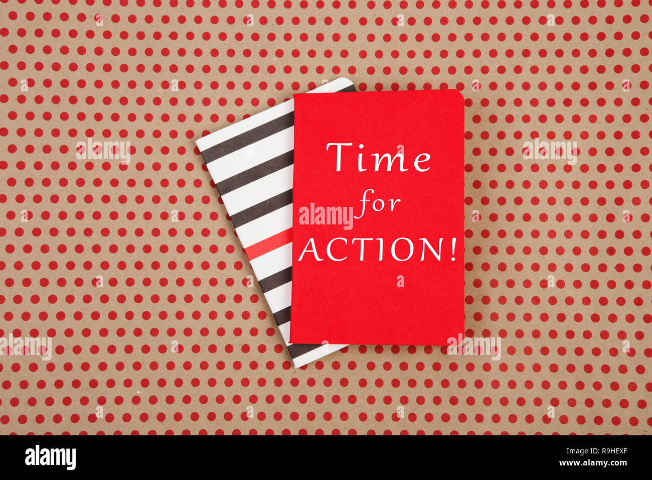 Des blocs-notes avec texte 'temps de l'ACTION !" sur fond de papier craft pois rouges Banque D'Images