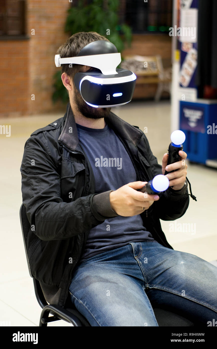 Dans l'homme casque VR qui profitant de jeu. La réalité virtuelle. l'homme à casque VR avec joysticks Banque D'Images