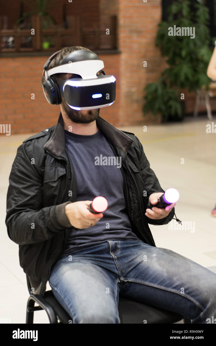 Dans l'homme casque VR qui profitant de jeu. La réalité virtuelle. l'homme à casque VR avec joysticks Banque D'Images