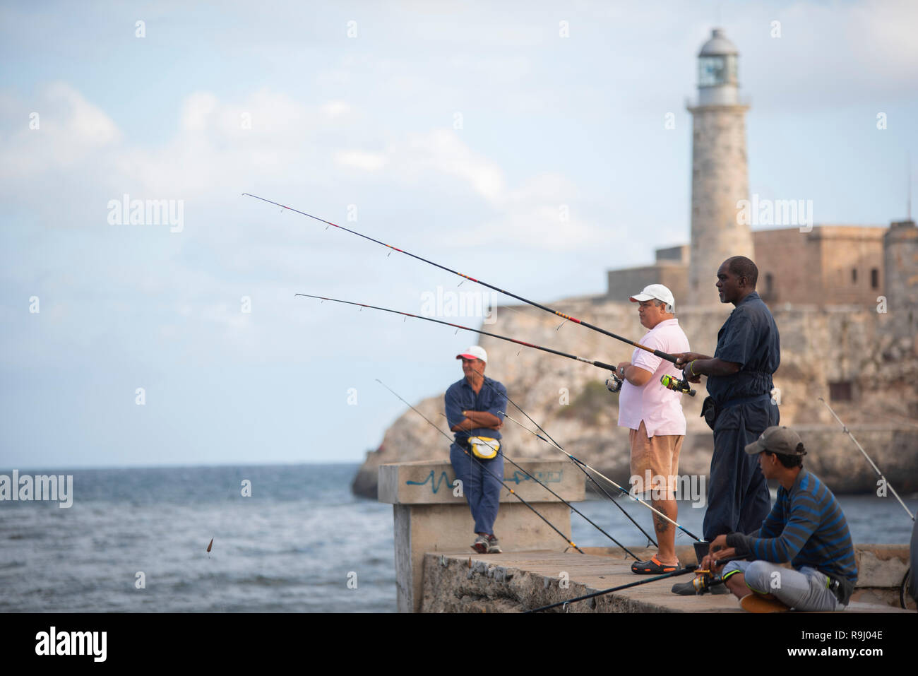 Peuple cubain la pêche au large de la jetée en face de la digue de Castillo del Morro à La Havane. Banque D'Images