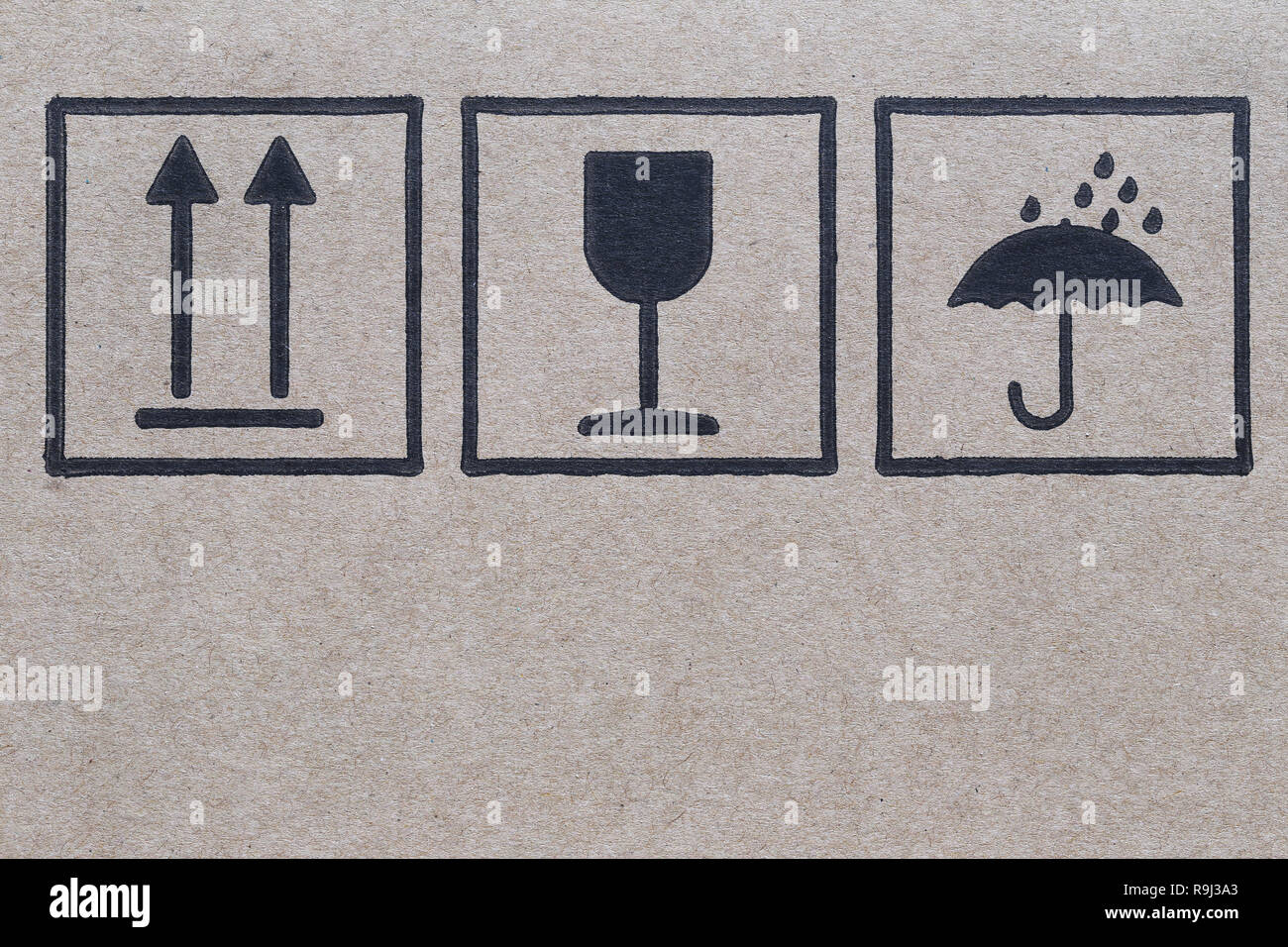 Logo symbole à côté d'une boîte en carton brun avec soin dans des transports. Banque D'Images