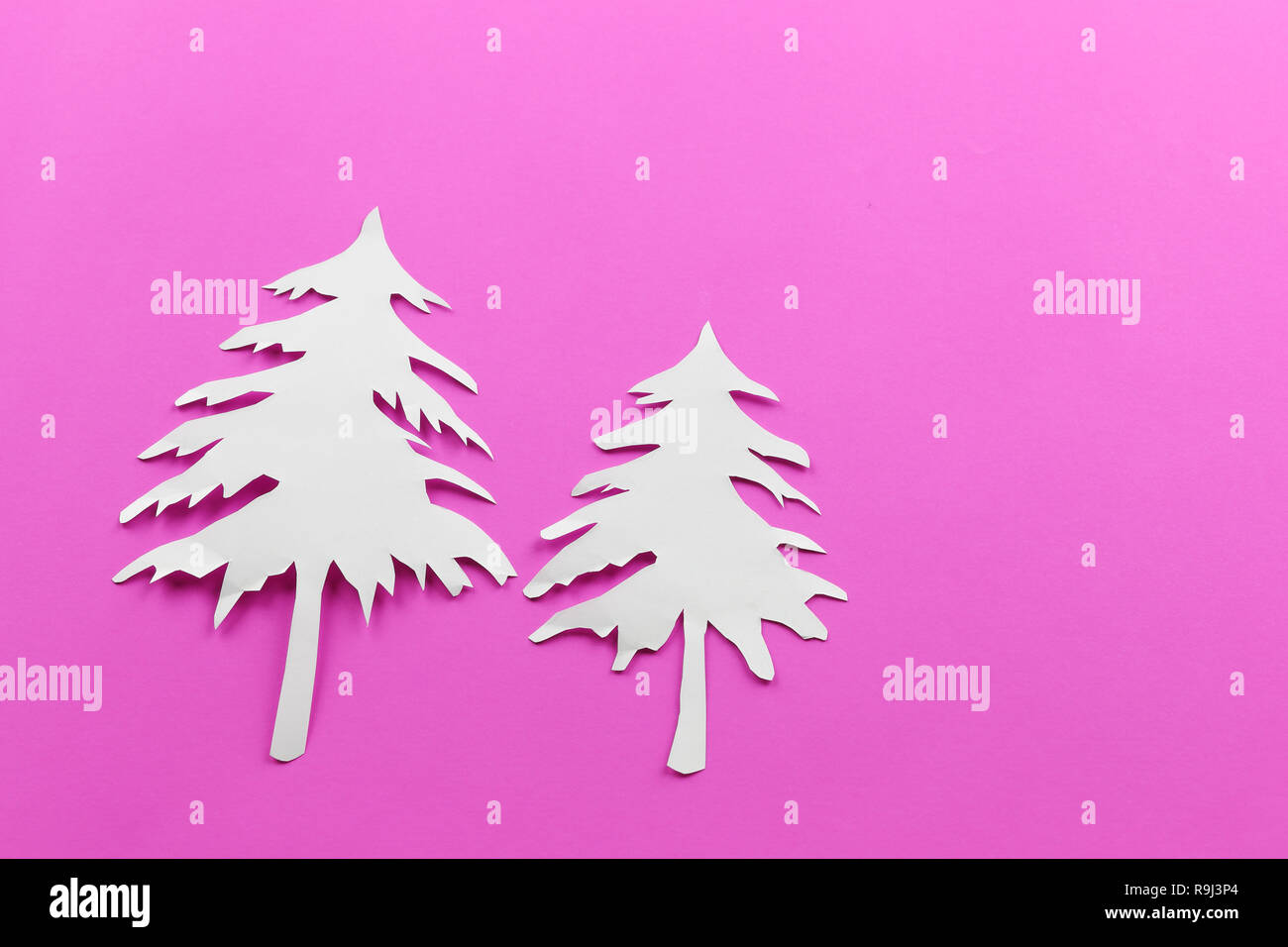 La forme de l'arbre de Noël de papier blanc sur du papier rose pour la conception en arrière-plan votre festival concept. Banque D'Images