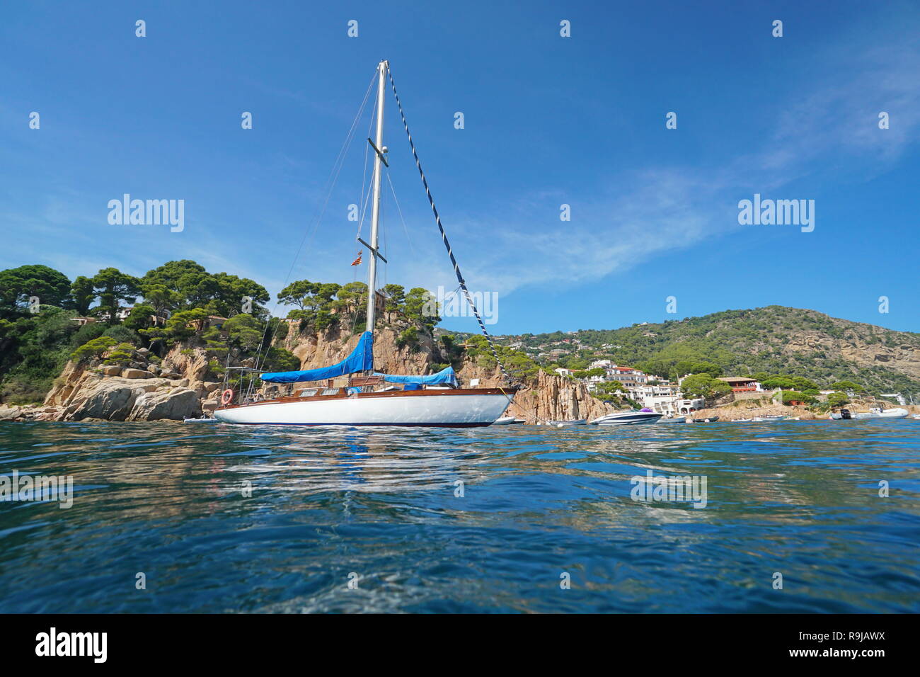 Espagne Un voilier amarré près de la côte rocheuse à Fornells de Mar village, Begur, Costa Brava, Catalogne, mer Méditerranée Banque D'Images