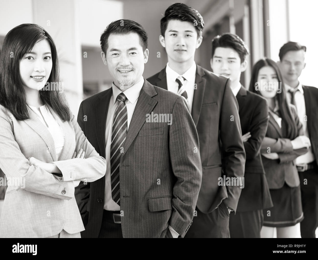 Portrait d'une équipe d'hommes et de femmes d'affaires asiatiques, smiling, noir et blanc. Banque D'Images