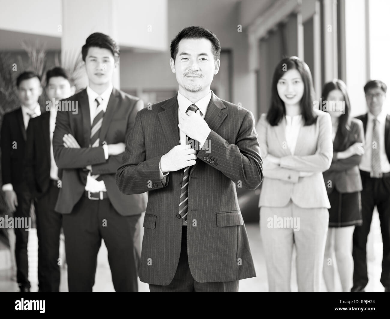 Portrait d'une équipe d'hommes et de femmes d'affaires asiatiques, smiling, noir et blanc. Banque D'Images