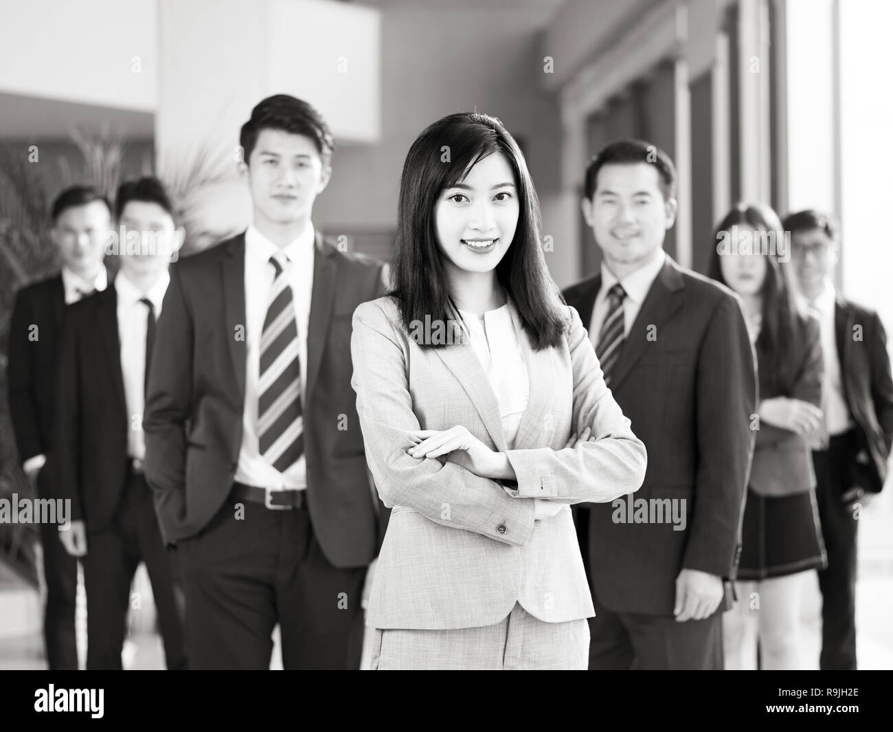 Portrait d'une équipe d'hommes et de femmes d'affaires asiatiques, smiling, noir et blanc. Banque D'Images