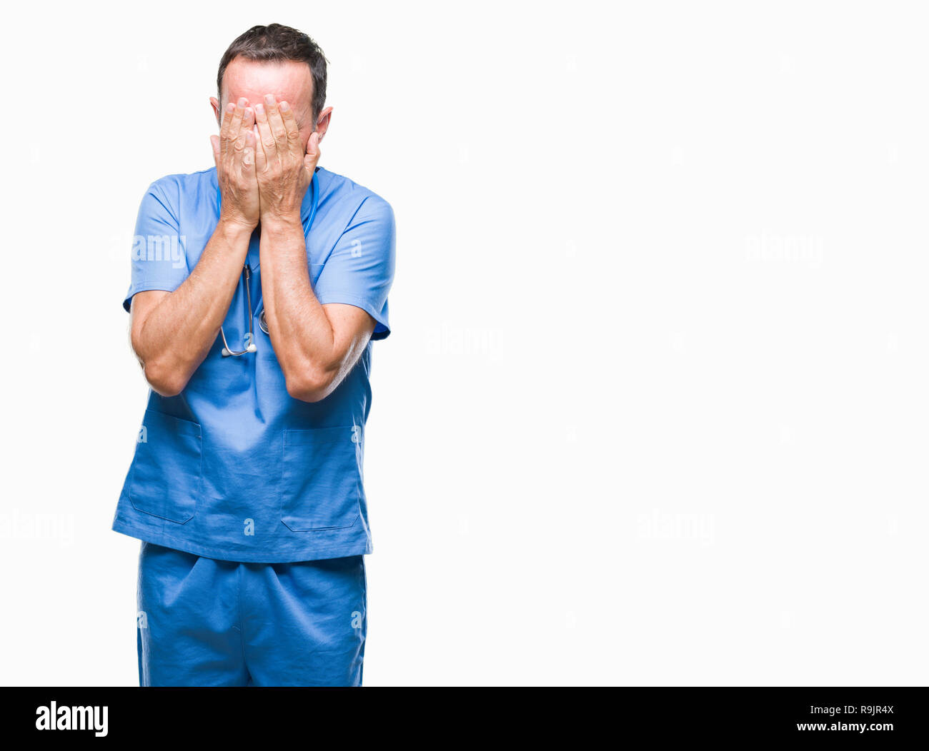 L'âge moyen le médecin senior homme portant uniforme sur l'arrière-plan médical isolé avec expression triste couvrant le visage avec les mains en pleurant. Appuyer sur Banque D'Images