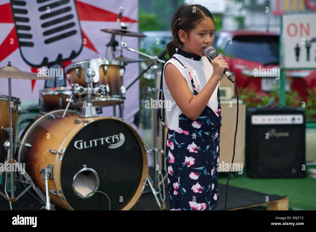 Une jeune fille thaïe sur scène pendant un concours de chant dans un marché du week-end, la ville de Phuket, Phuket, Thaïlande Banque D'Images