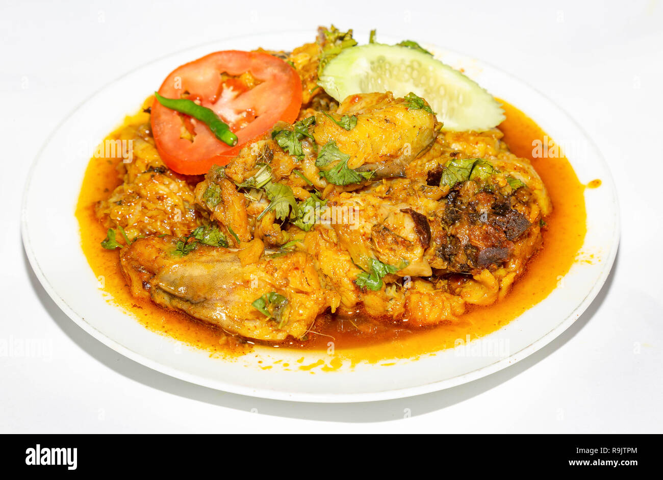 La cuisine du nord de l'Épicé populairement connu comme Dhania poulet avec tranches de concombre et de tomate isolé sur fond blanc. Banque D'Images