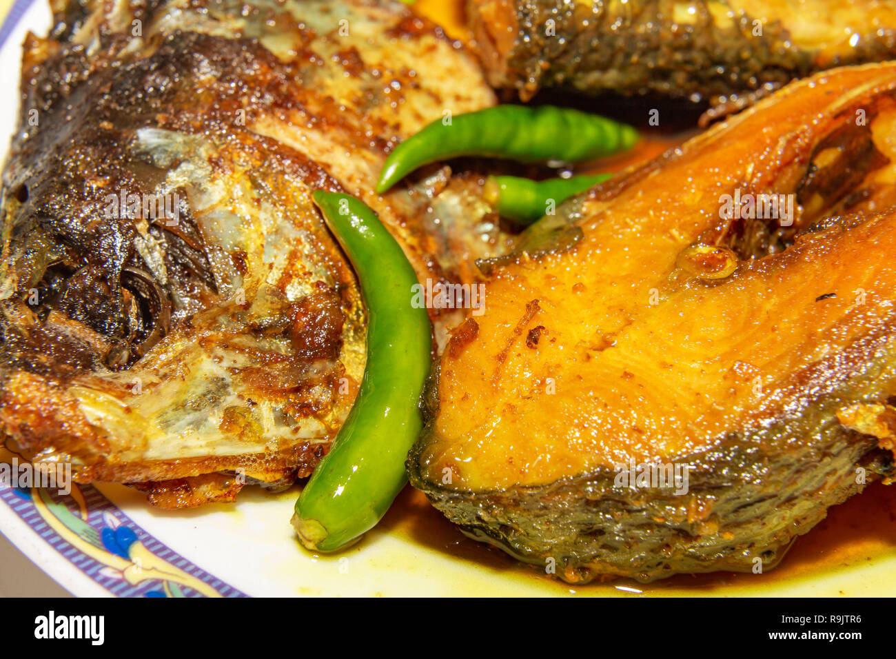 Aliments pour poissons indiens traditionnels préparés avec du poisson frit avec Hilsa profondément avec piment vert en gros plan macro-vision. Banque D'Images