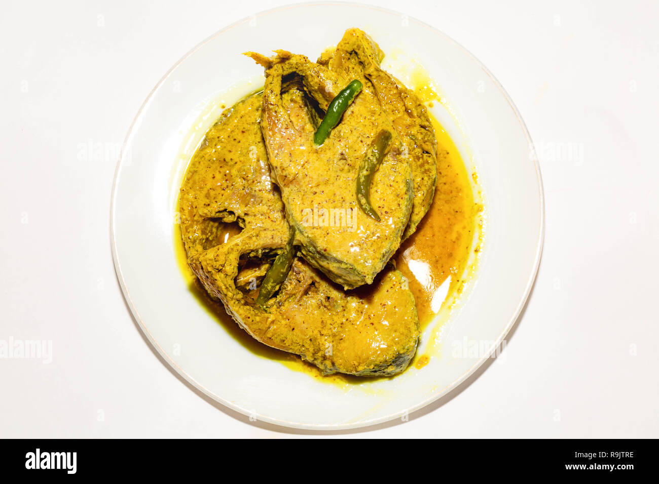 Poisson indien épicé traditionnelle préparée avec de délicieux poissons en sauce moutarde Hilsa avec piment vert. Banque D'Images