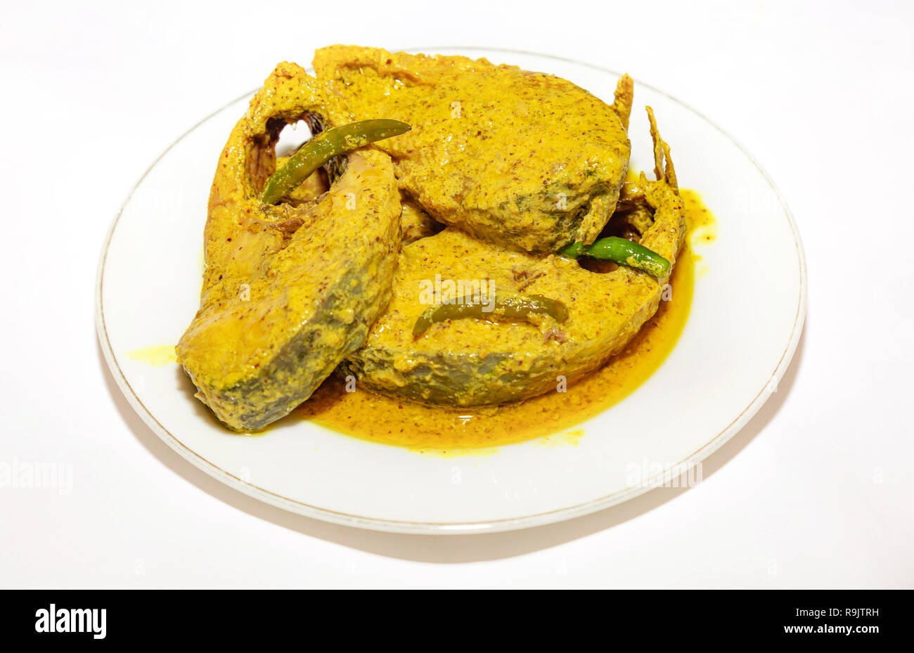 Poisson indien épicé traditionnelle préparée avec de délicieux poissons en sauce moutarde Hilsa avec piment vert. Banque D'Images
