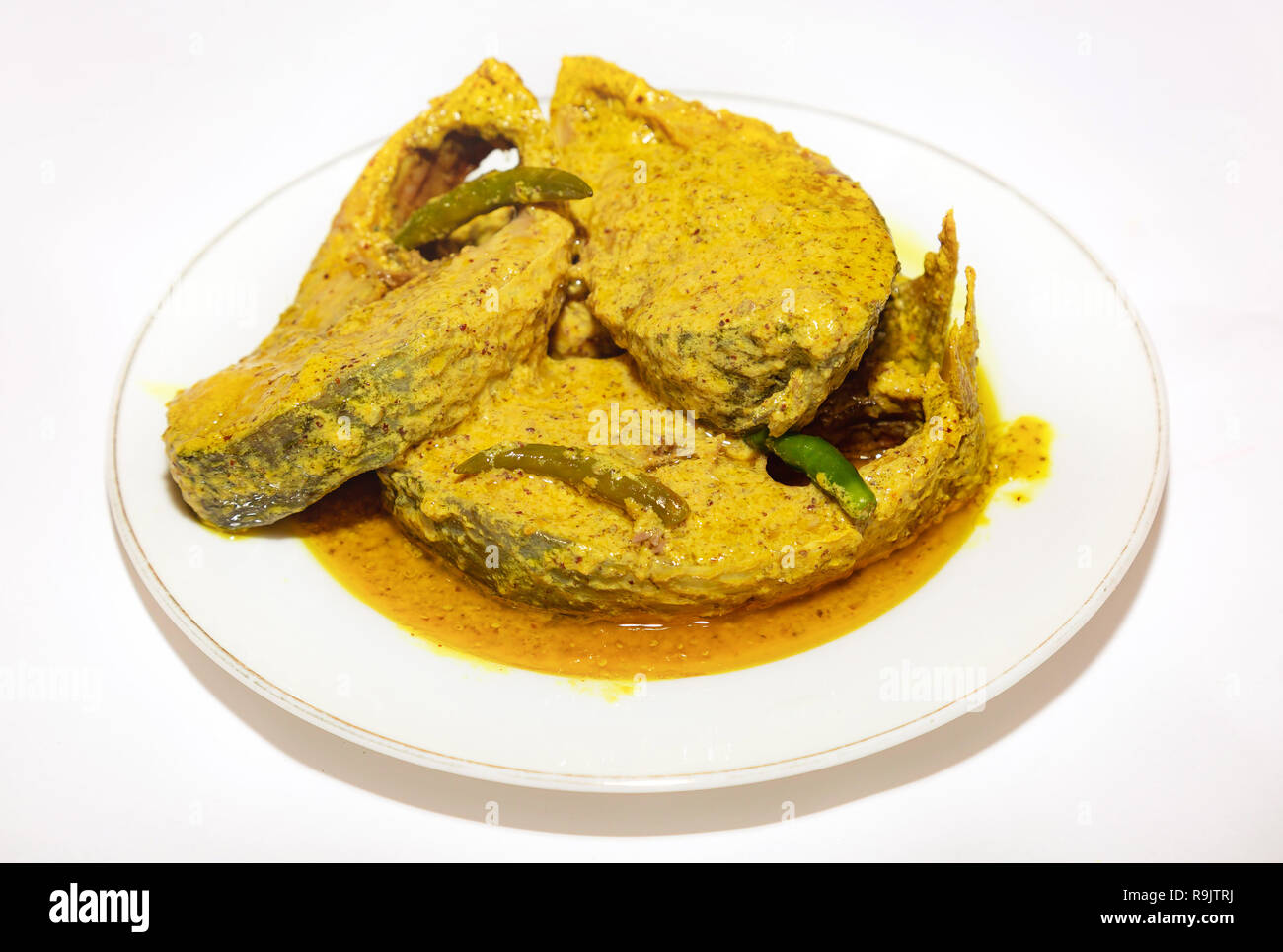 Poisson indien épicé traditionnelle préparée avec de délicieux poissons en sauce moutarde Hilsa avec piment vert. Banque D'Images