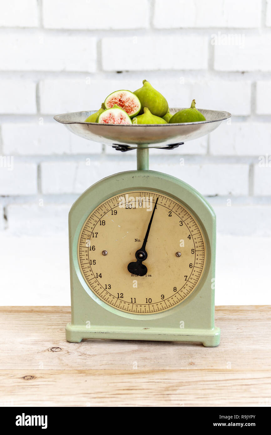 Balance de cuisine rétro / antique et figues mûres, coupées en deux sur la table en bois naturel Banque D'Images