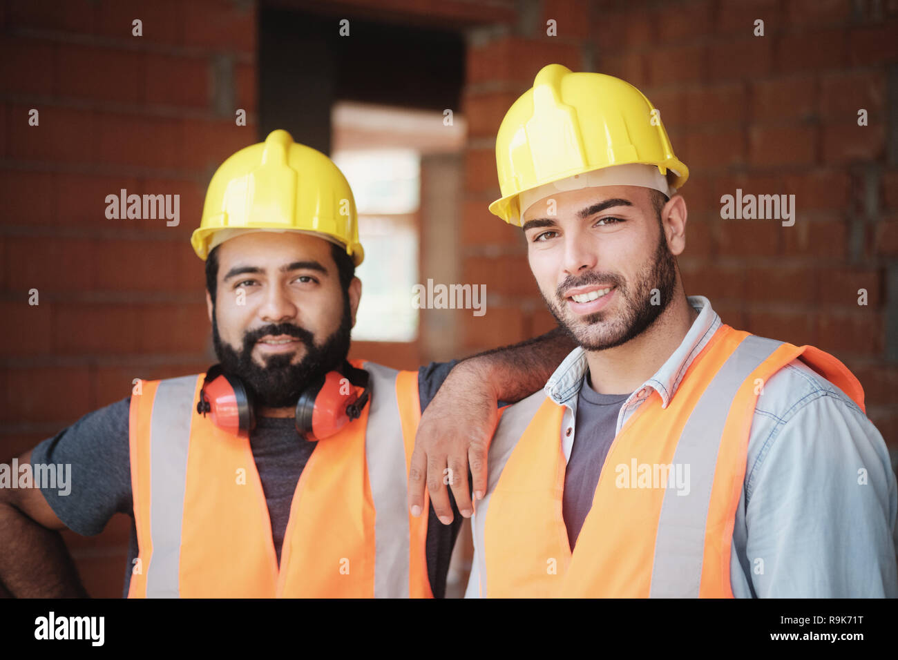 Les personnes travaillant dans la construction du site. Portrait de professionnels de l'homme au travail dans la nouvelle maison à l'intérieur de bâtiment. Les professionnels à la recherche et en souriant Banque D'Images
