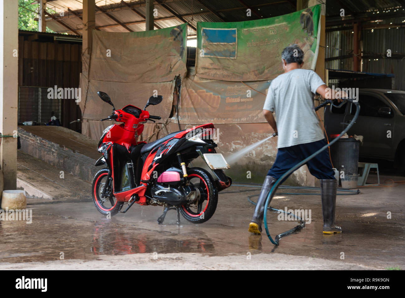 Vieil homme laver votre moto avec nettoyeur haute pression au lavage de  voiture shop Photo Stock - Alamy