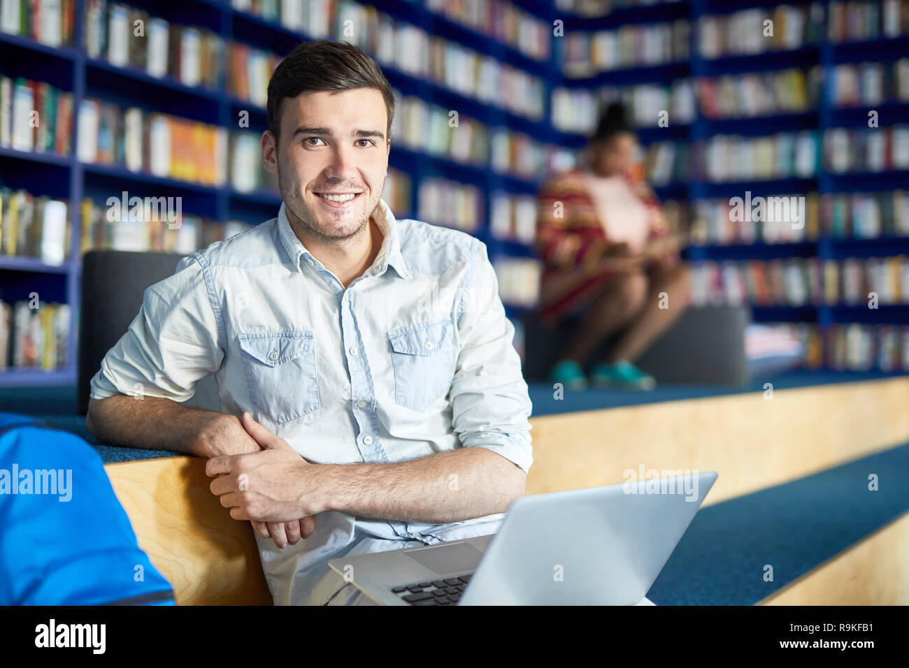 Handsome student guy dans bibliothèque moderne Banque D'Images