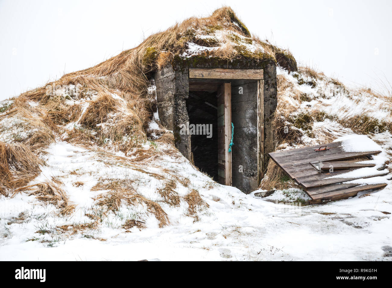 Vieille cave avec porte brisée couverte de neige. L'Islande Banque D'Images