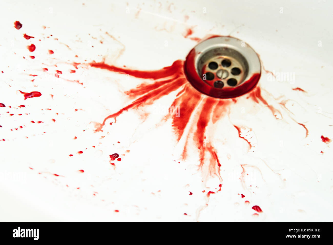 Vidange de bains de sang blanc du bassin. Les taches de sang dans le waterbasin trou. Exécuter avec le sang couler d'inondations. Dripples peinture rouge pour la vidange d'un lavabo. Banque D'Images