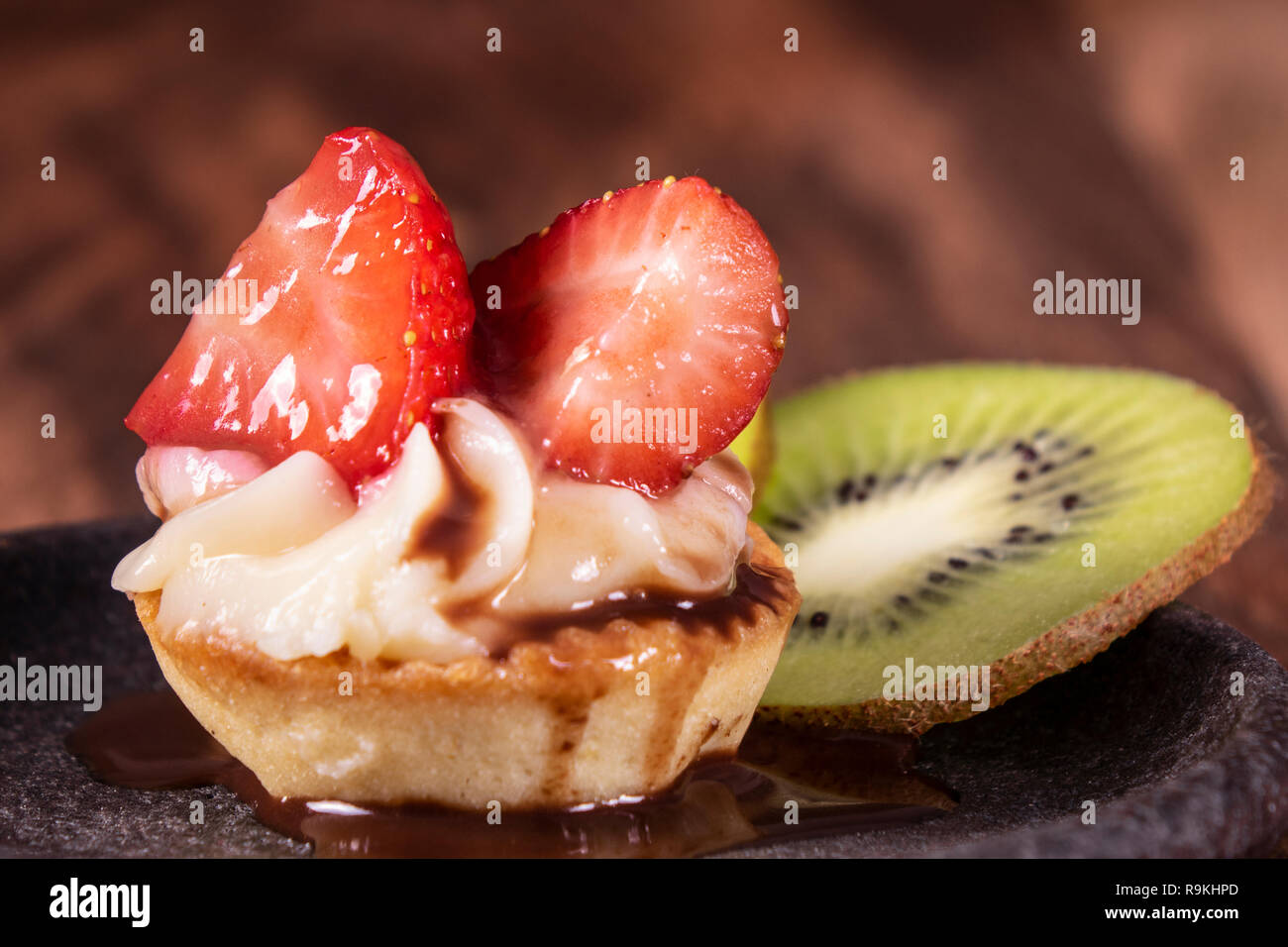 Tarte aux fruits et de petits fruits dessert avec kiwi et fraise sur fond de bois. Délicieux gâteau sucré frais avec des fraises, kiwi et crème. Banque D'Images