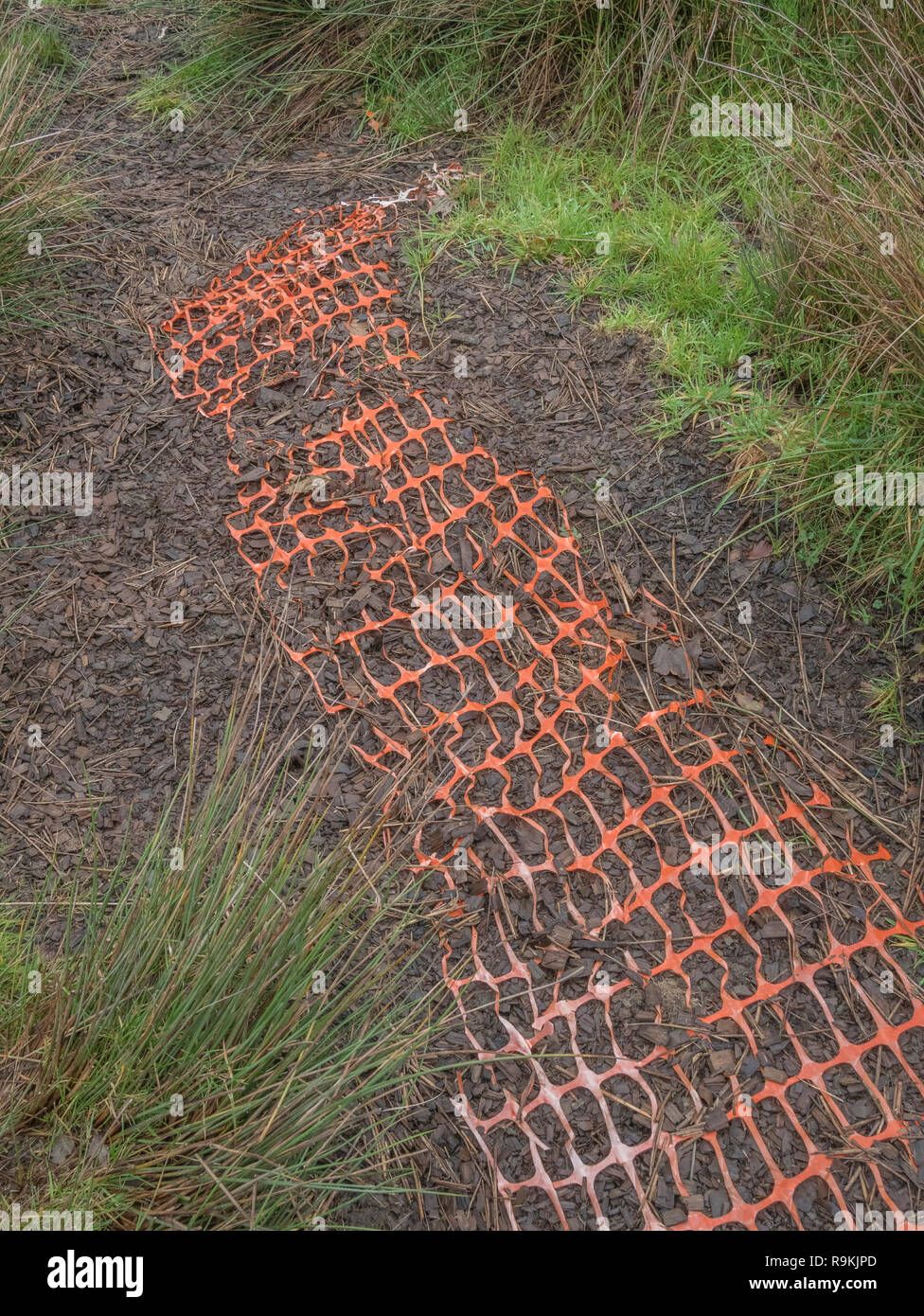 Tronçon abandonné de orange industriel barrière. Défenses cassées, métaphore plastique dans la campagne, de clôtures de sécurité. Banque D'Images