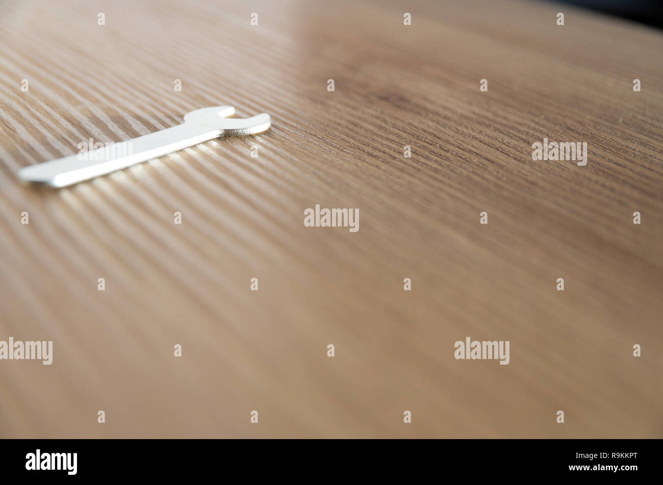 Petite clé sur un banc en bois isolé Banque D'Images