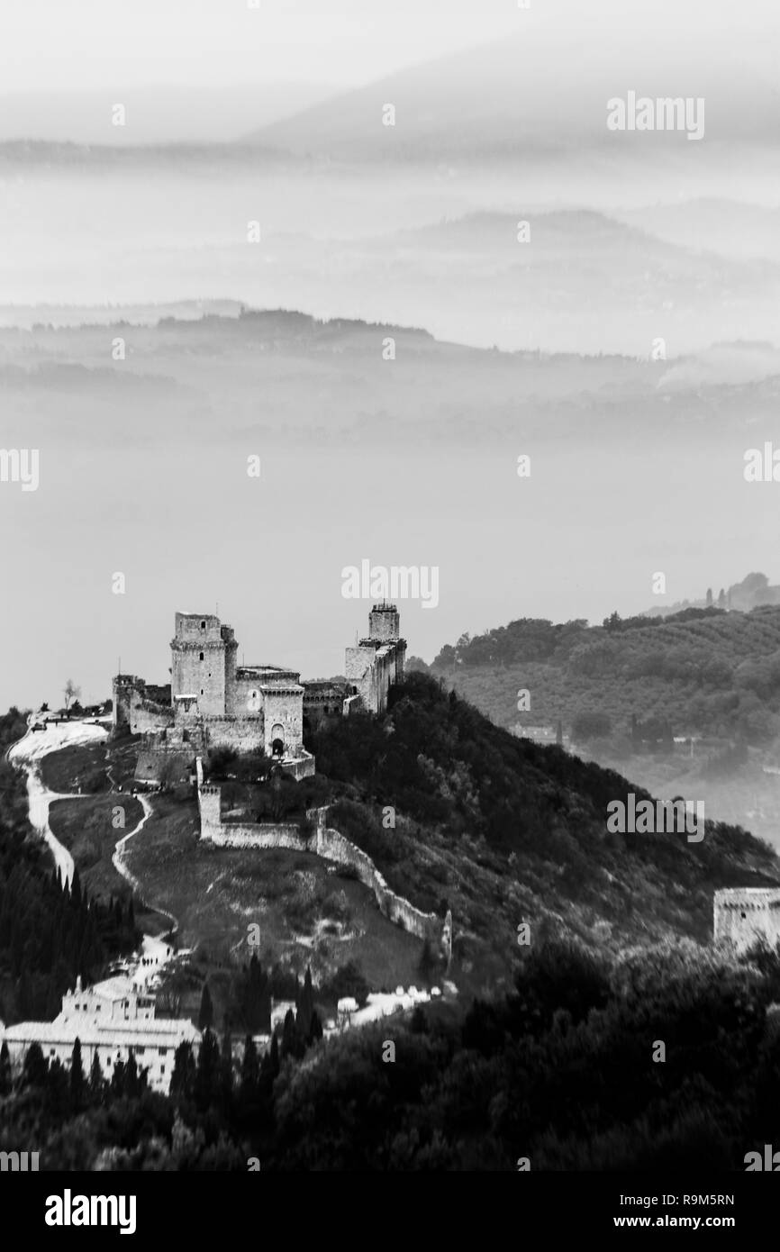 Belle vue sur le château de Rocca Maggior (Assise, Umbrfia, Italie) sur une mer de brume, avec des collines en arrière-plan Banque D'Images