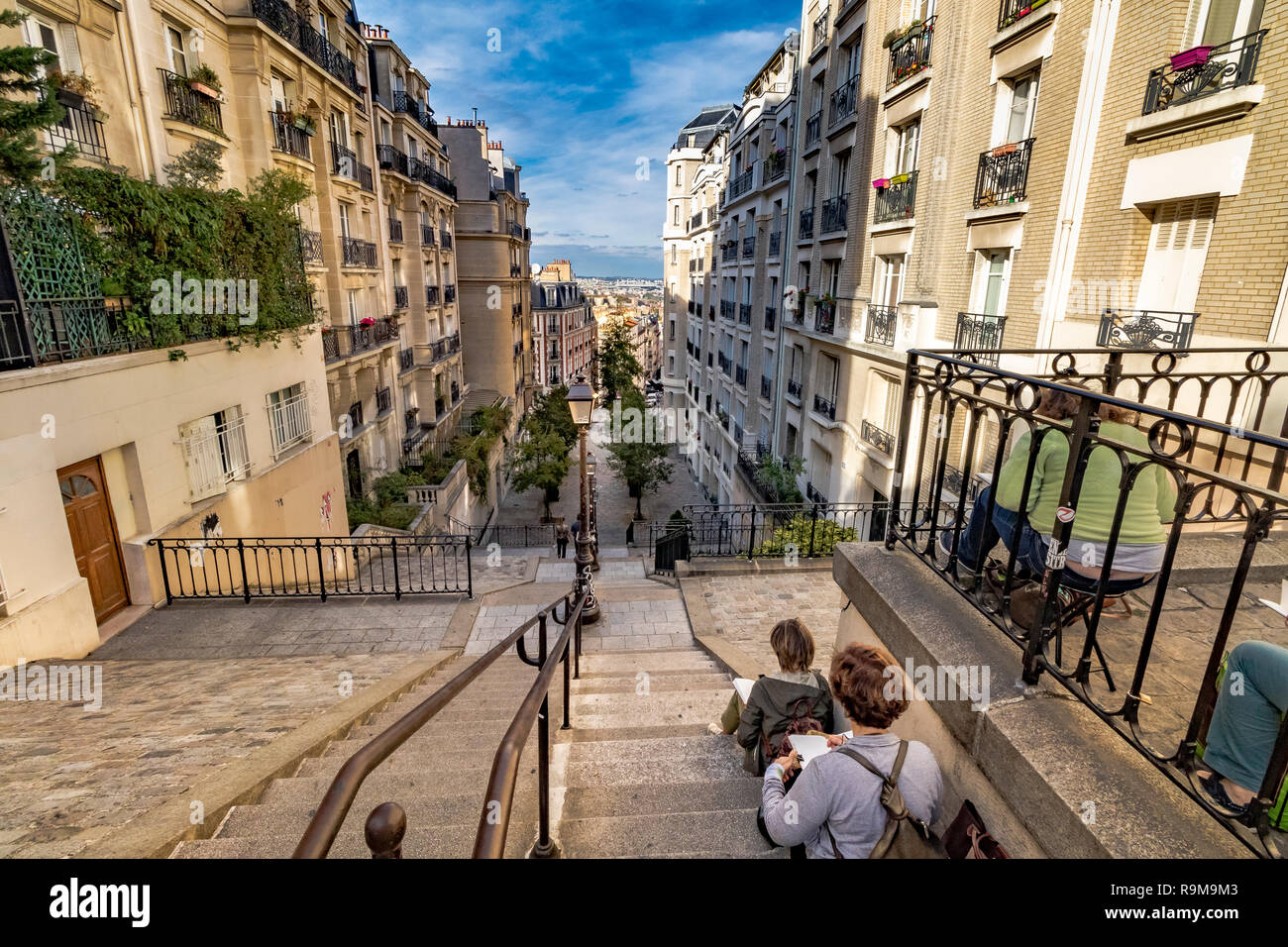 Des gens assis avec des blocs de croquis sur les escaliers de la rue du Mont Cenis, une série de marches raides à Montmartre, Paris, France Banque D'Images