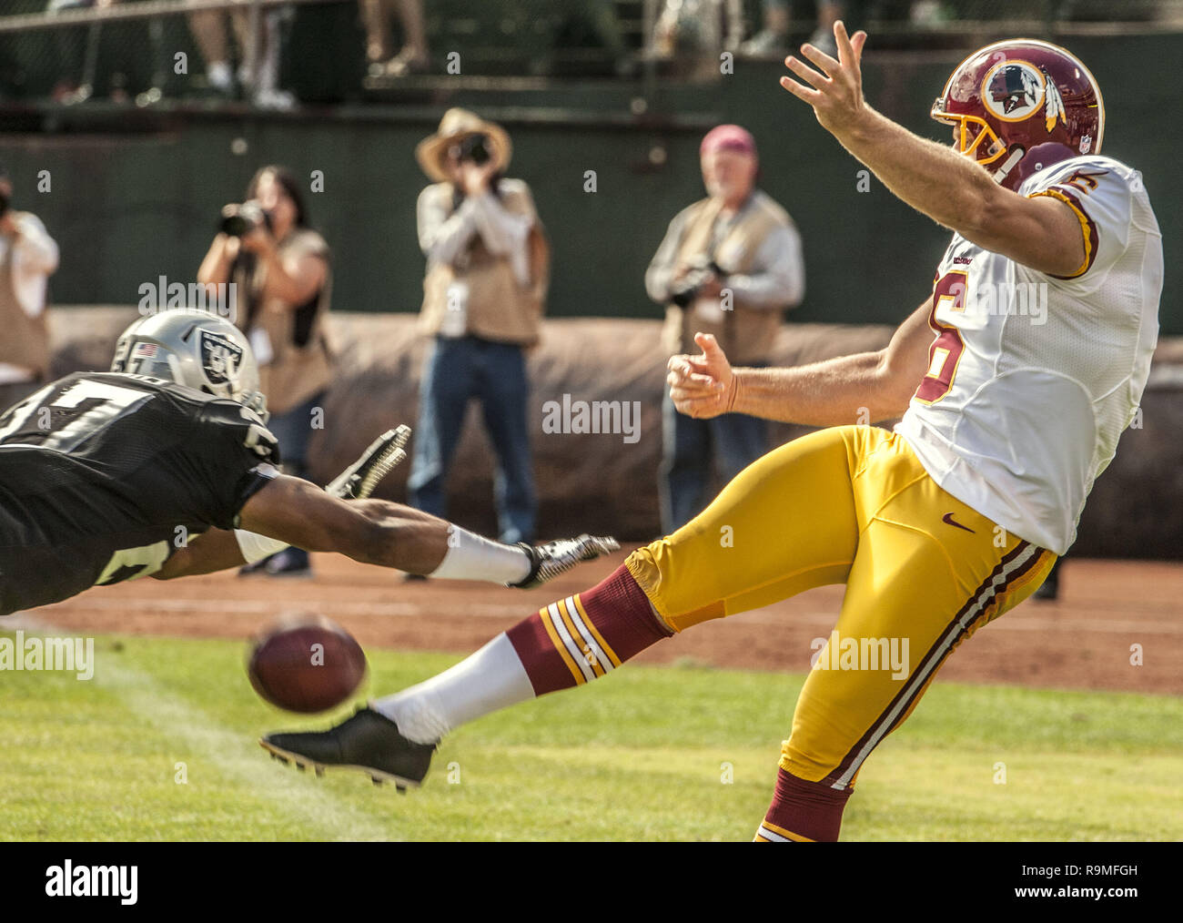 Oakland, Californie, USA. 29 août, 2013. Oakland Raiders running back Rashad Jennings (27) blocs Redskins de Washington punter Sav Rocca (6) punt le Dimanche, Septembre 29, 2013, dans la région de Oakland, Californie. Les Redskins défait les Raiders 24-14. Crédit : Al Golub/ZUMA/Alamy Fil Live News Banque D'Images