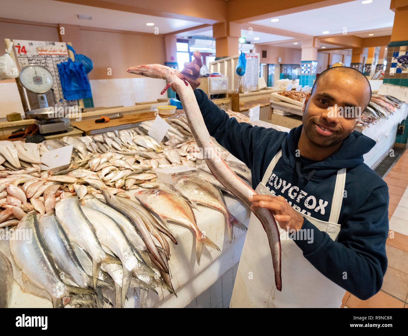 Homme tenant au souk de poisson anguille à Nag'aat Al Kout à Fahaheel , Koweït, au Moyen-Orient. Banque D'Images