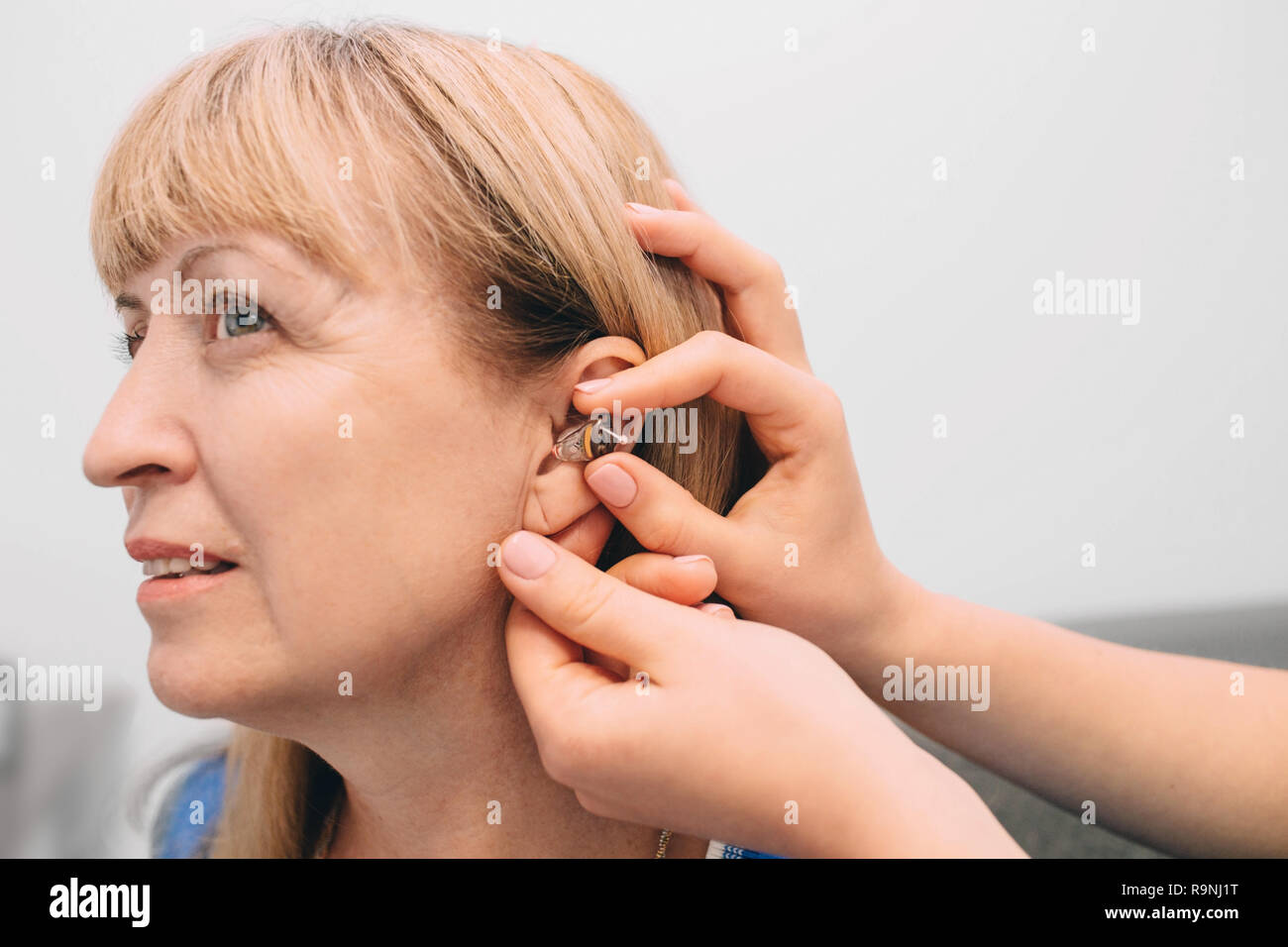 La main coupée de réglage de l'aide auditive femmes médecin Banque D'Images