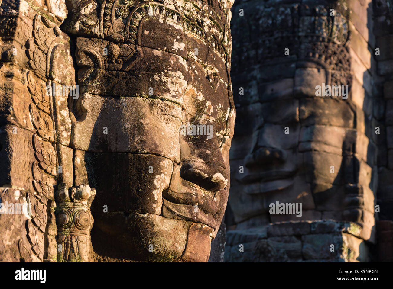 Visages de pierre à Bayon, temple Angkor Thom, selective focus coucher de la lumière. Concept la méditation, célèbre destination touristique au Cambodge, voyage Banque D'Images