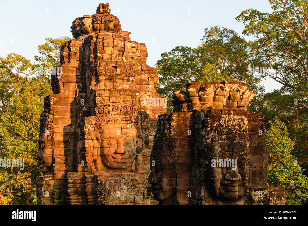 Visages de pierre à Bayon, temple Angkor Thom, selective focus coucher de la lumière. Concept la méditation, célèbre destination touristique au Cambodge, voyage Banque D'Images