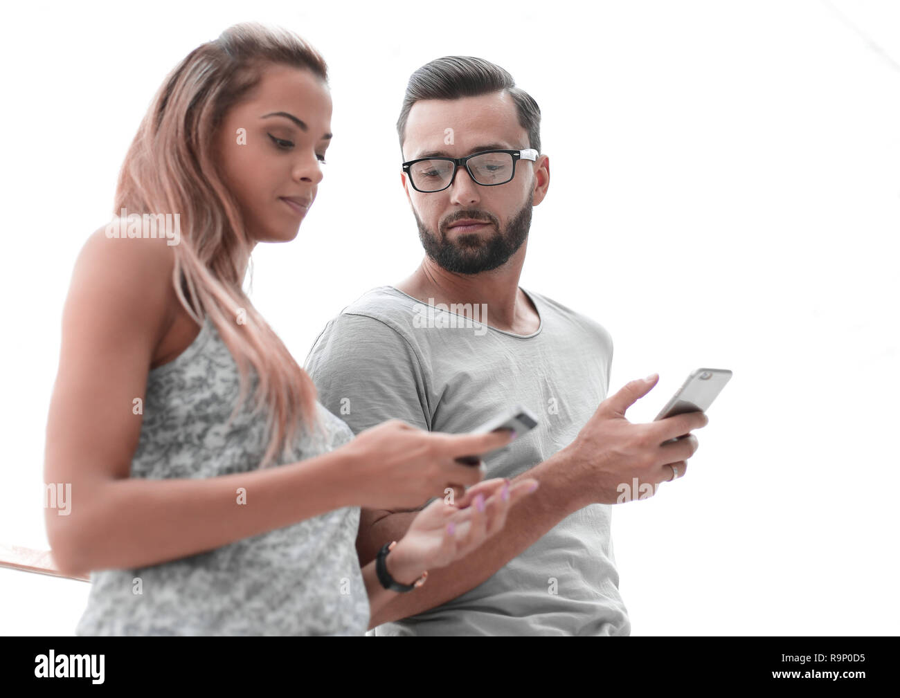 Jeune couple à la recherche à l'écran de leur smartphone Banque D'Images