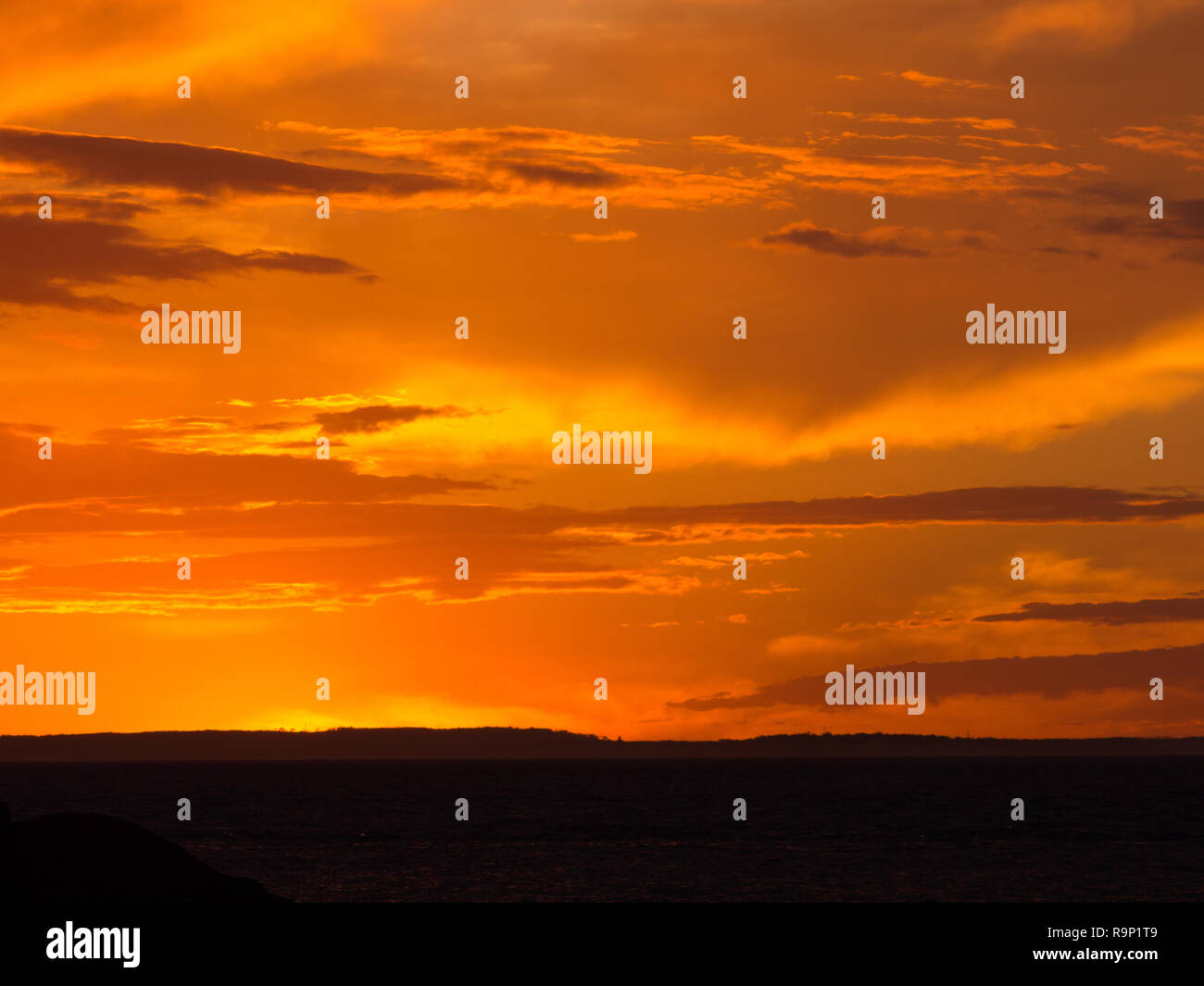 Coucher du soleil orange avec des nuages sur l'océan à Penneshaw sur Kangaroo Island en Australie du Sud, Australie. Banque D'Images