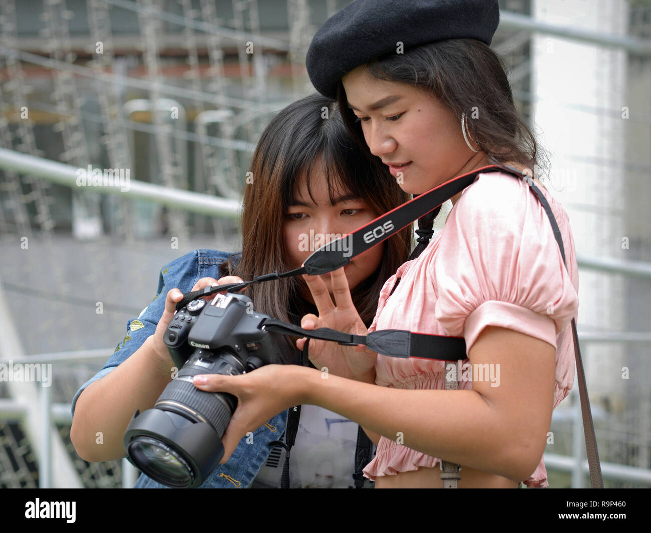 Deux filles Thai vérifier leur portrait photos sur l'écran LCD d'un Canon EOS 750D appareil photo reflex numérique. Banque D'Images