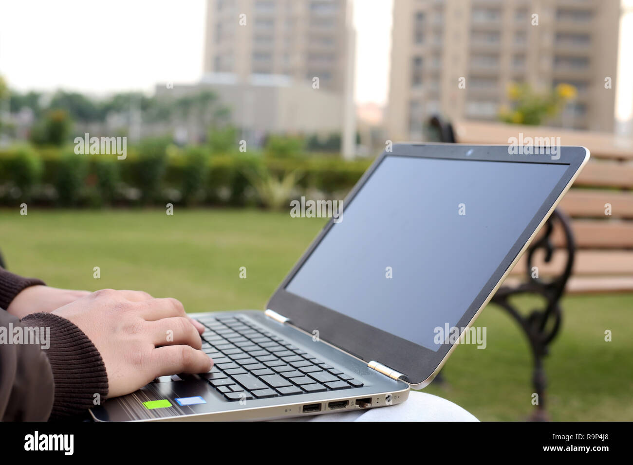 L'homme est à l'aide d'ordinateur portable en parc. Banque D'Images