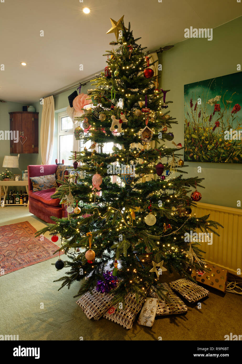 L'arbre de Noël décoré et éclairé dans une maison. Présente en dessous. Banque D'Images