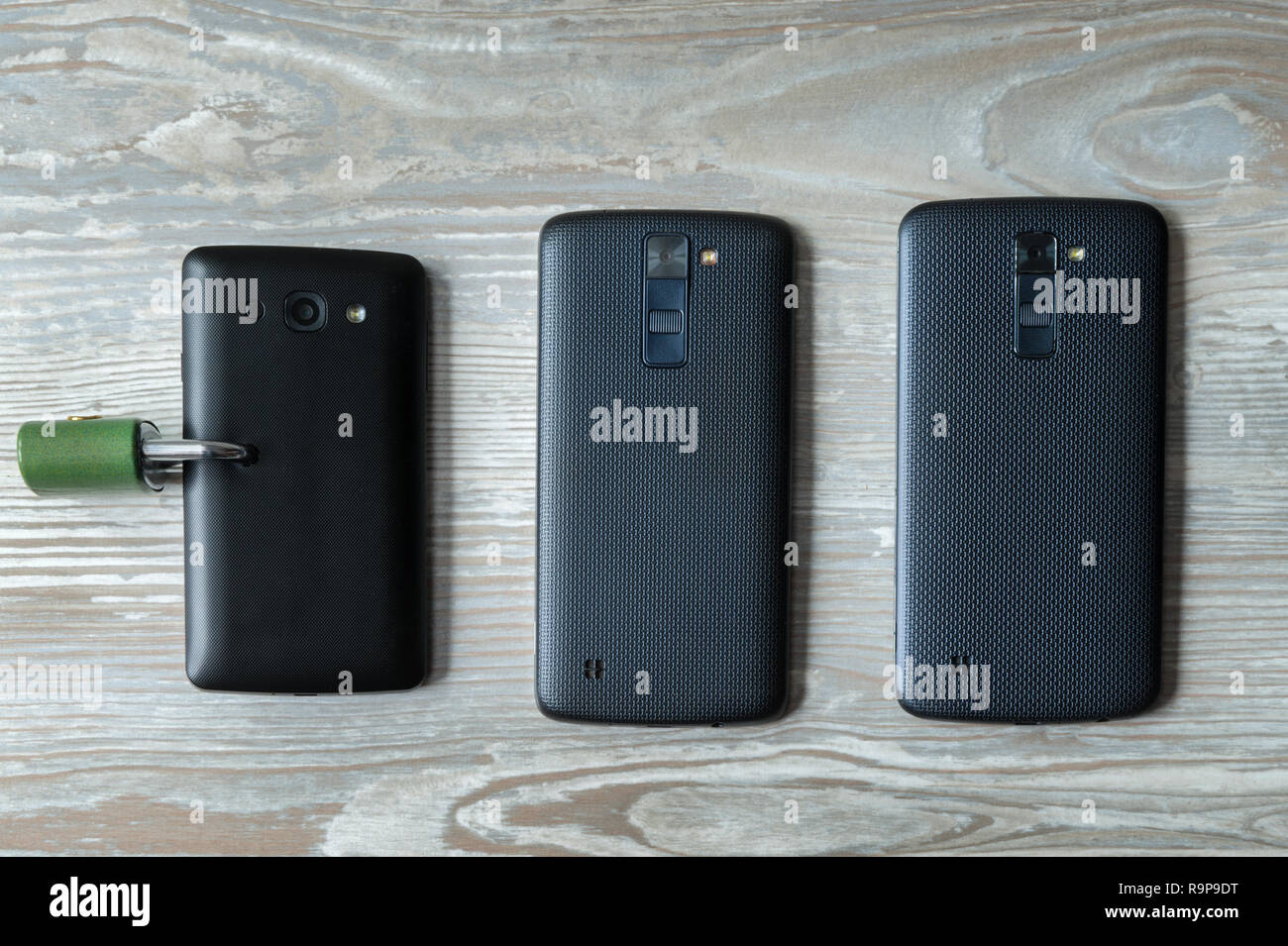 Trois mobile phones un avec un cadenas dans l'écran Banque D'Images