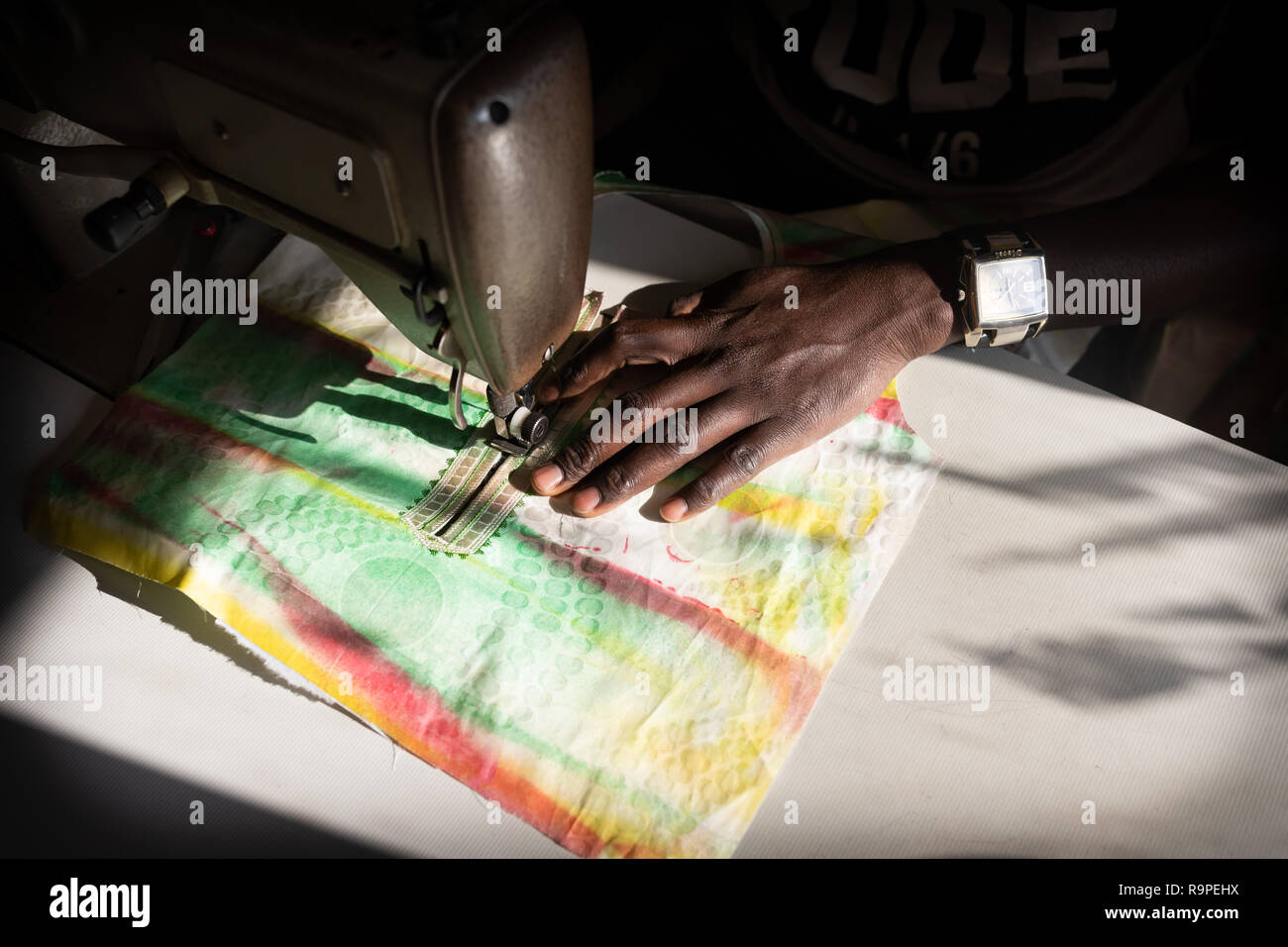 Un homme africain coud un vêtement dans la Communauté de l'Afrique principalement de goutte d'Or à Paris Banque D'Images