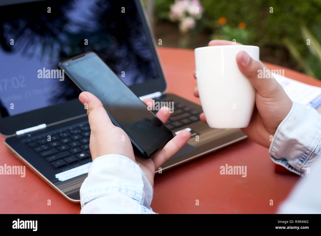 L'homme est mise en attente et tasse de café dans la main avec un ordinateur portable sur la table. Banque D'Images