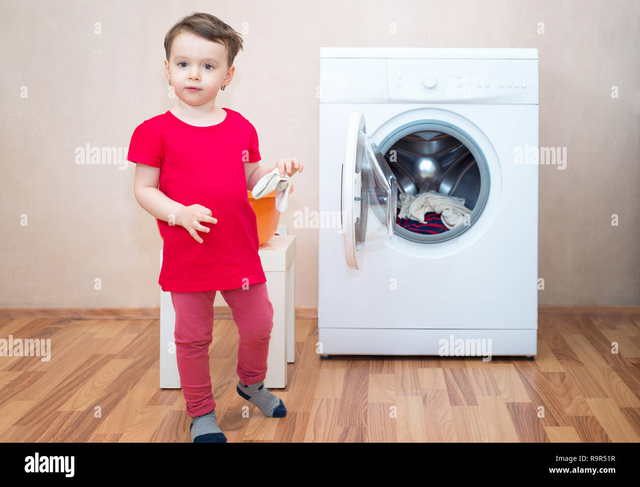 Petite fille et lave linge dans l arriere plan Photo Stock Alamy