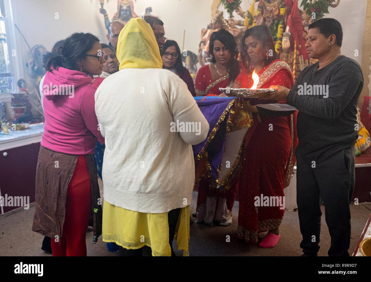 Un hindou congrégation en effectue le rituel de Arti propose des flammes et à des divinités. Dans le Queens, New York. Banque D'Images